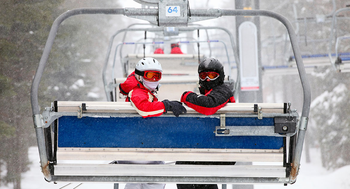 Esquiadores iniciantes no teleférico