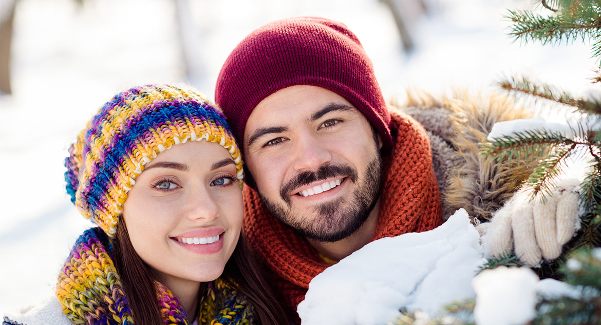 casal na neve vestindo gorro e acessórios de neve