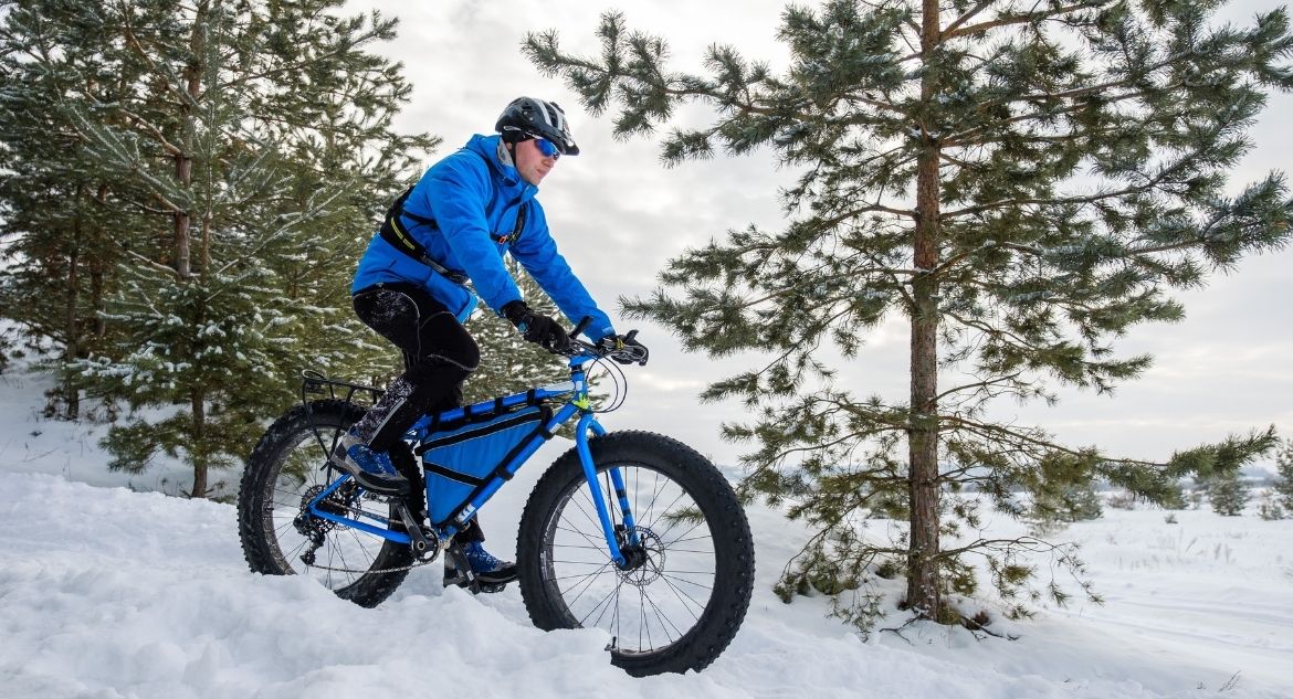 Homem andando de mountain bike na neve