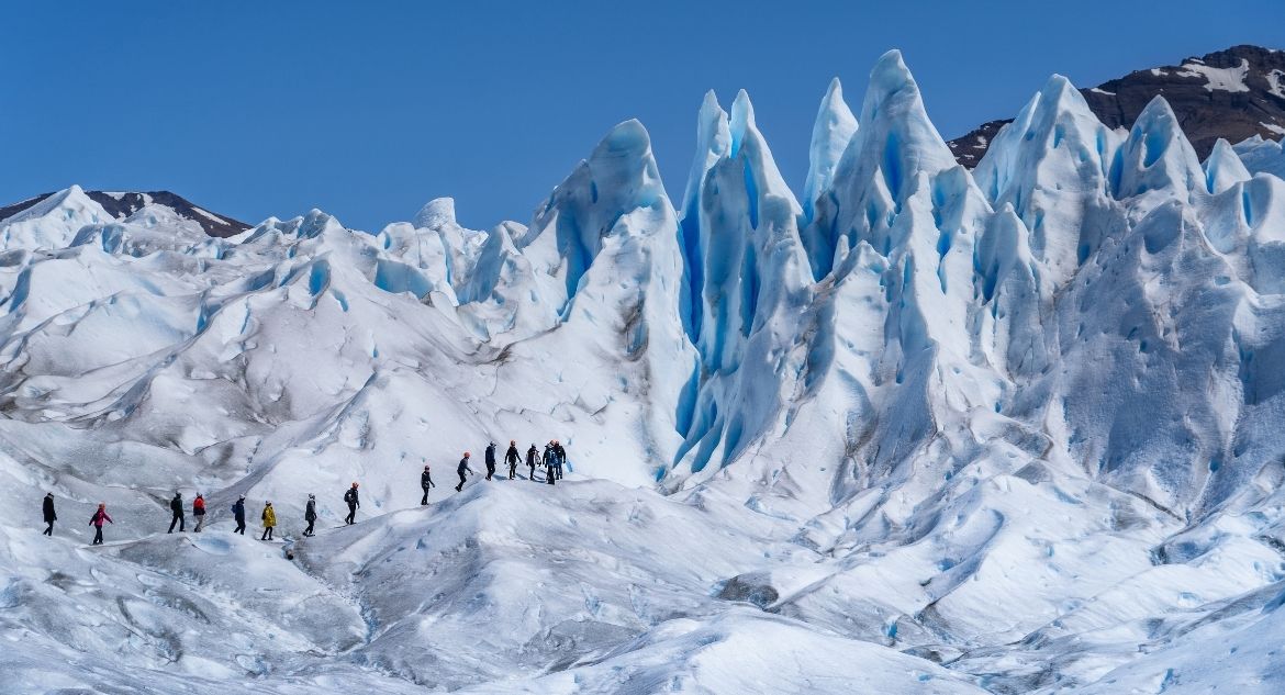 Grupo praticando trekking na geleira perito moreno