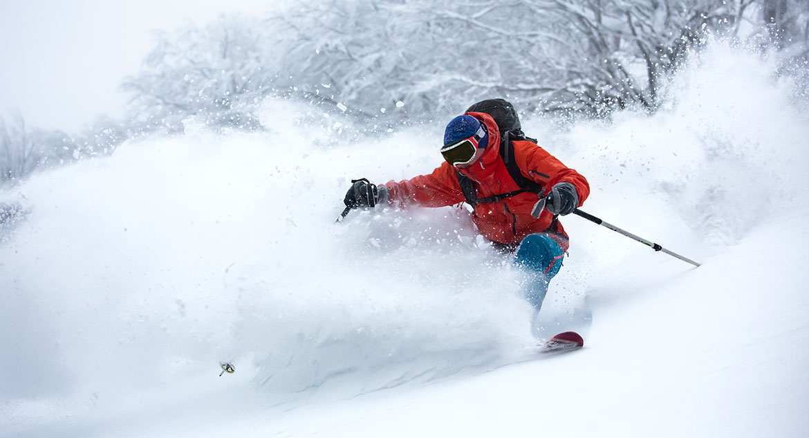 Um homem esquiando em neve powder.