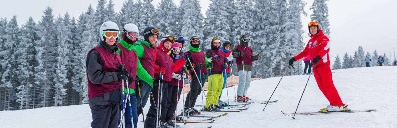 Grupo de esquiadores iniciantes em aula de esqui