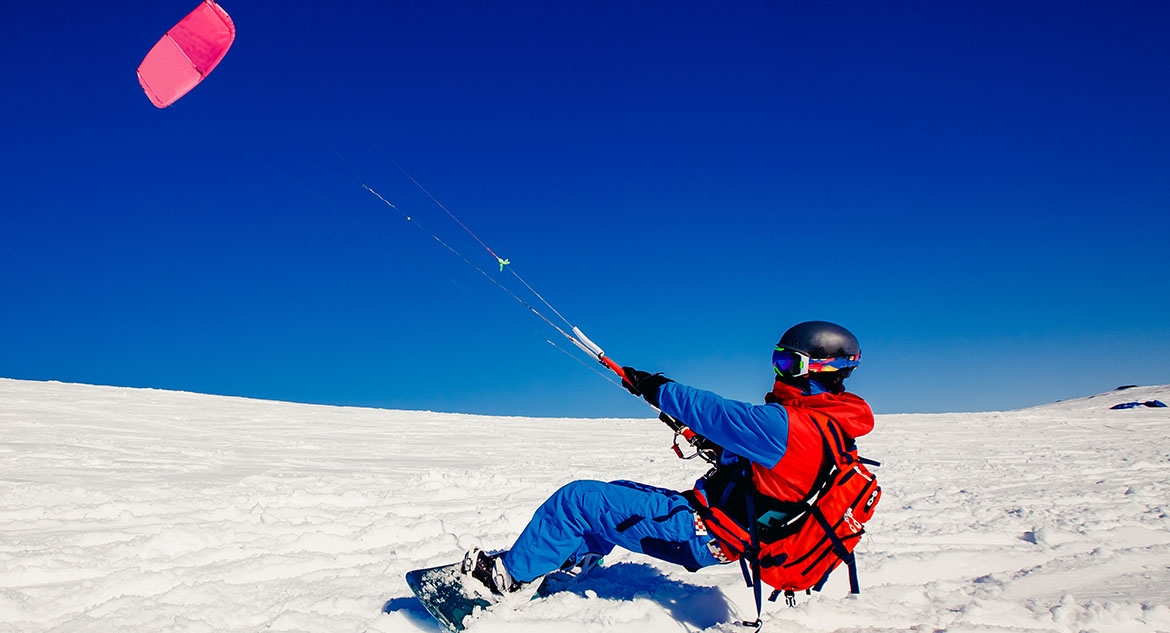 homem praticando o snowkite na neve